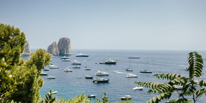 Boats sailing in Amalfi Coast against sky
